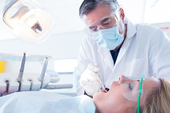Un dentiste examine les dents de sa patiente. Un dentiste examine les dents de sa patiente.