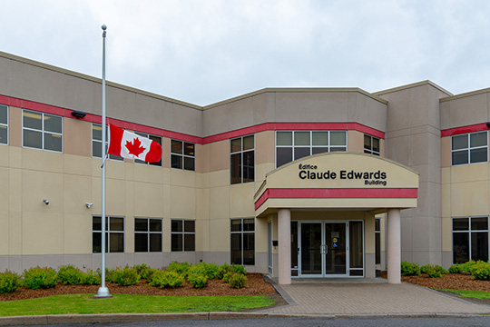 Canada’s national flag flying at half-mast during National Public Service Week at the Claude Edwards Building in Ottawa in memory of the passing of Federal Retirees members.