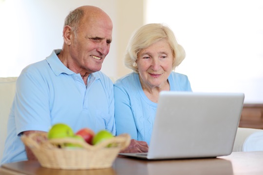 A man and woman using a laptop computer.