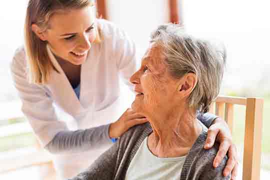  Visiteur de santé et une femme âgée lors d'une visite à domicile.