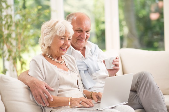 Heureux couple senior avec un ordinateur portable.