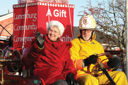 Cheryl Lamerson and husband Will Brooks greet the crowds while aboard an antique fire truck during last November’s Lunenburg Santa Parade. Cheryl Lamerson and husband Will Brooks greet the crowds while aboard an antique fire truck during last November’s Lunenburg Santa Parade.