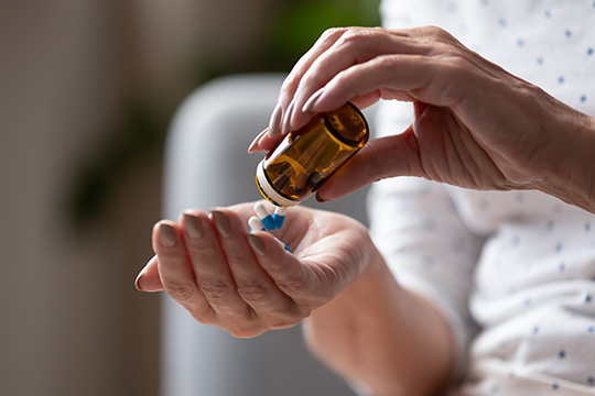 Hands holding a bottle of pills