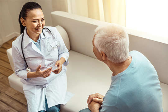 A man having a conversation with his physician on a couch Man having deprescribing conversation with a physician