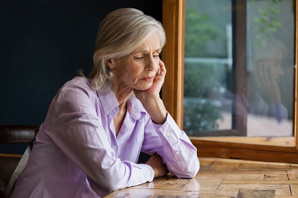 Une femme assise à une table regardant pensivement vers le bas Les retraités fédéraux plaident pour des pensions équitables