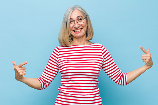 Une femme souriante dont les bras sont dirigés vers elle Répondez à notre enquête