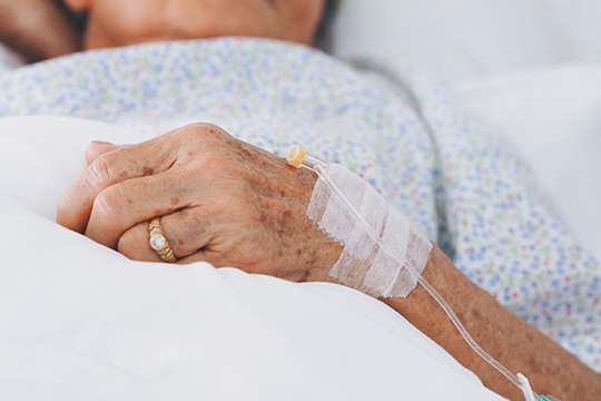 Les Canadien·ne·s méritent de meilleurs soins de longue durée. La main d'une personne âgée en milieu hospitalier.