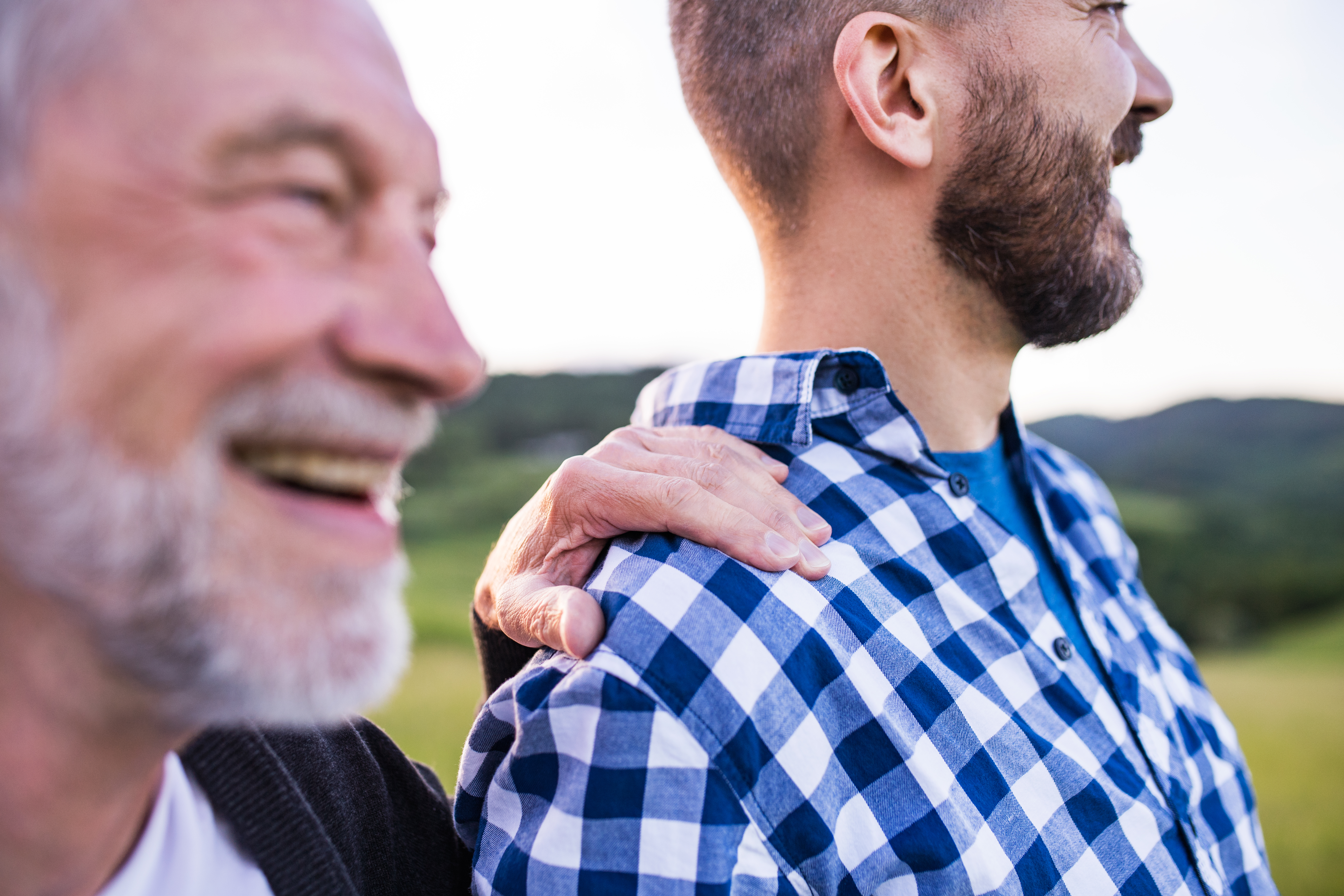 Older adult man with son outside. 