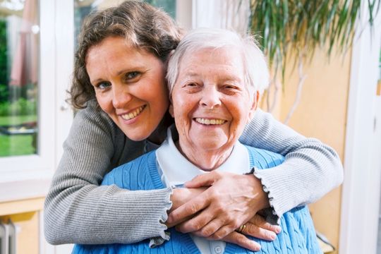 Home caregiver assisting a woman.