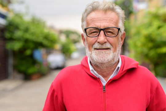 Adult man standing outdoors.