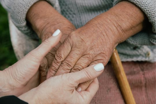 British Columbians deserve safe long-term care. Long-term care resident holding hands with caregiver.