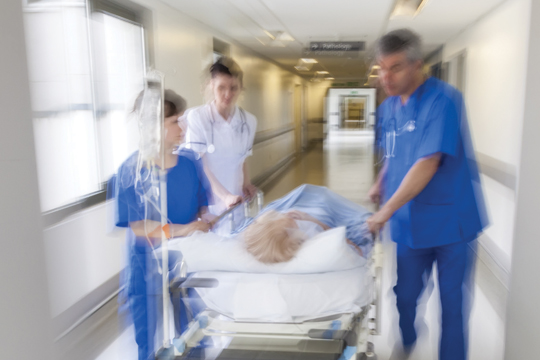 Doctors rushing a patient down a corridor.