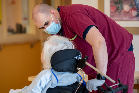 Un technicien médical des Forces armées canadiennes discute avec une résidente de l’Hôpital Sainte-Anne de Montréal. Un technicien médical des Forces armées canadiennes discute avec une résidente de l’Hôpital Sainte-Anne de Montréal.