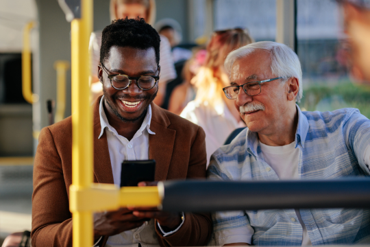 Young man with a senior man on the city bus.