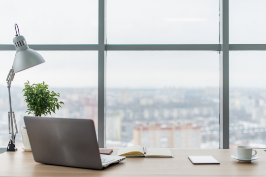 Office desk with windows and city view.