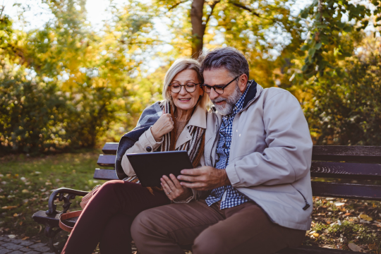 Couple adulte assis avec une tablette.