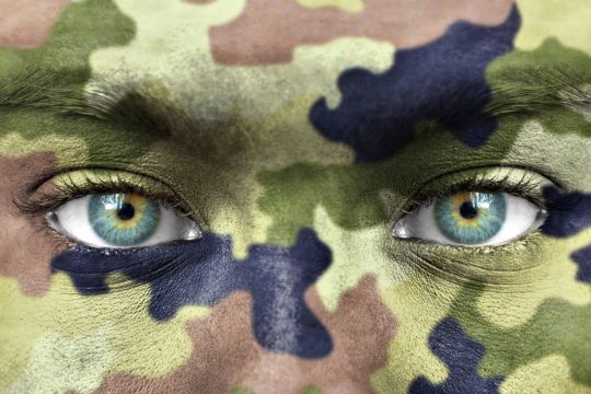 Woman wearing camouflage makeup.