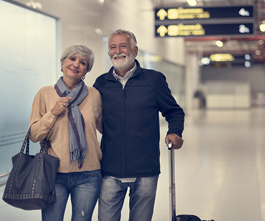 ​​Senior couple walking in an airport.