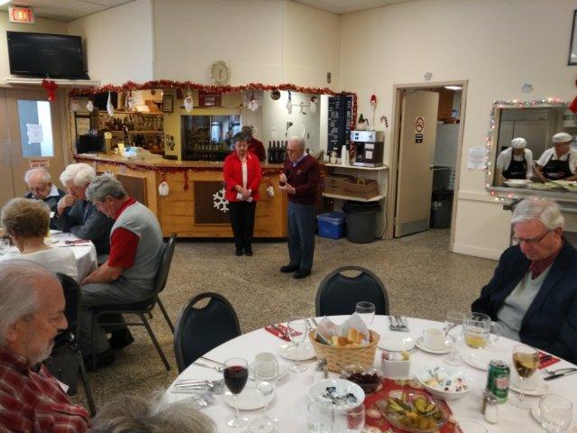 A man speaking to a group gathered for a banquet A man speaking to a group gathered for a banquet