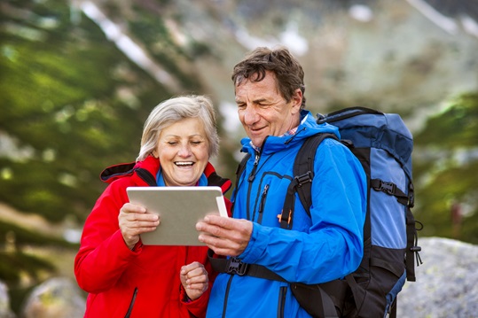 Un couple qui utilise leur tablette pendant la randonnée. Un couple qui utilise leur tablette pendant la randonnée.