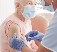 Elderly woman receiving vaccine.