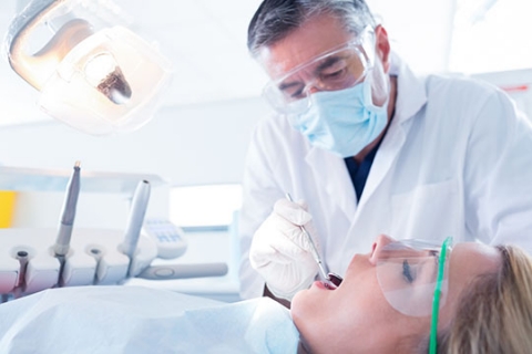 Un dentiste examine les dents de sa patiente. Un dentiste examine les dents de sa patiente.