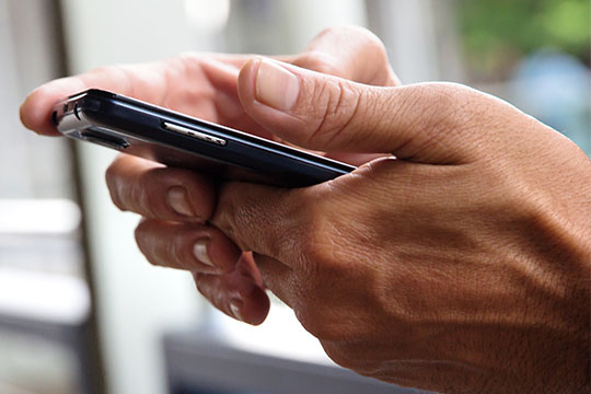 Hands holding a cellphone Smartphone screen limits.