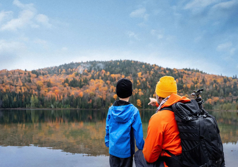 Father and son look across a lake.