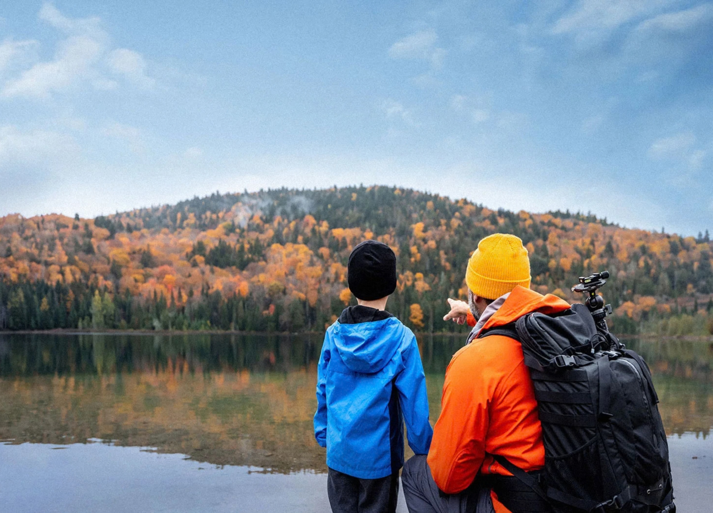 Father and son look across a lake.
